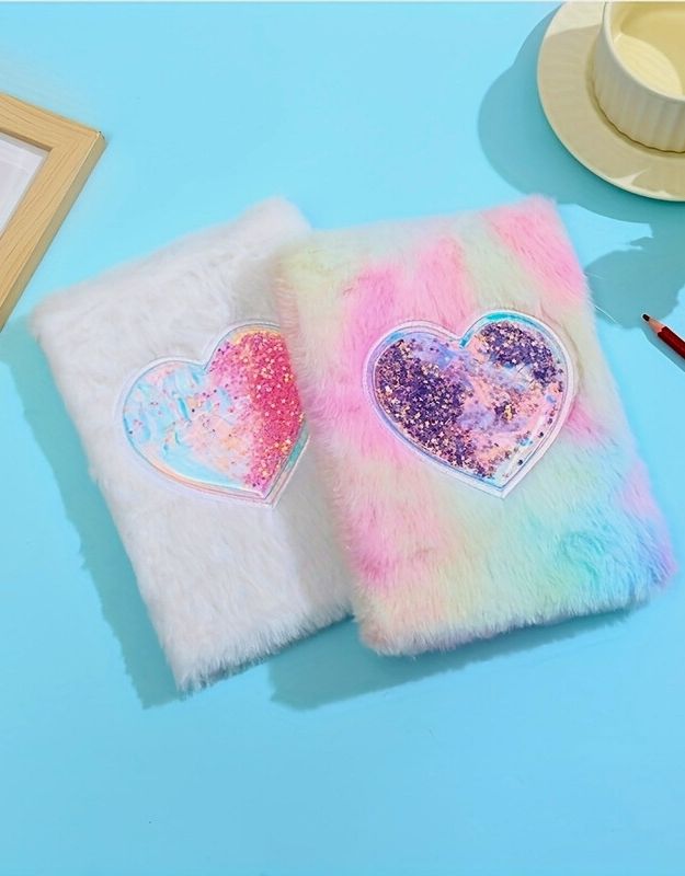 Two fluffy notebooks with heart-shaped, glittery stickers on a light blue surface.